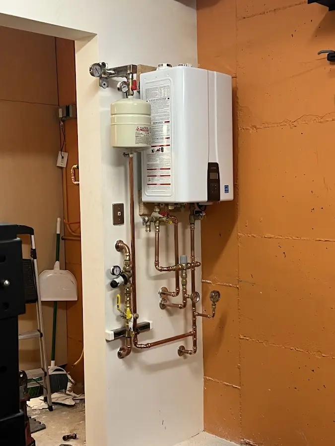Plumbing technician inspecting water heater connections in Boothbay